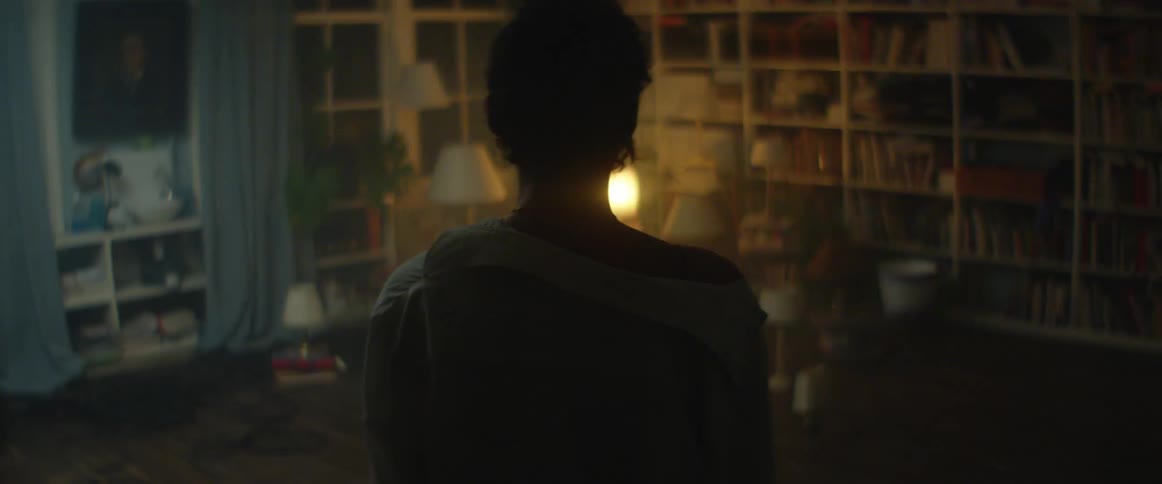 A person stands at the entrance to a room and watches as lamps flash on and off rapidly