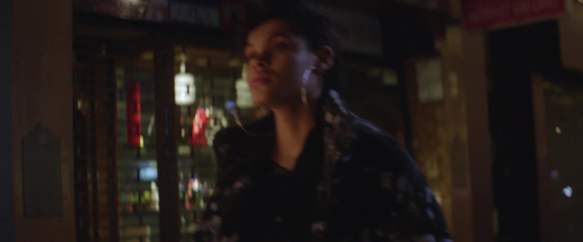 Woman walking down a city street at night