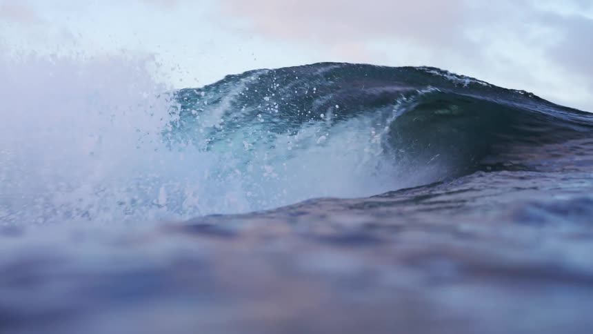 Wide shot of a wave hitting water