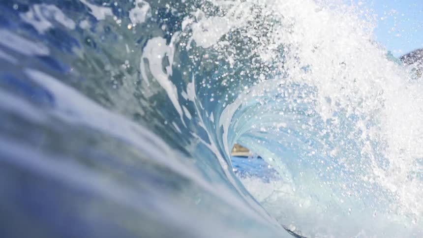 A blue ocean wave crashing down in the sea