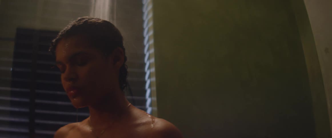 Young woman taking a shower in the bathroom at home at night