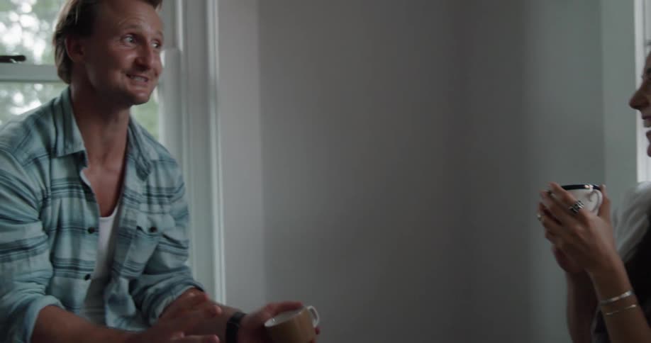 A woman and a man are hanging out indoors while having a conversation