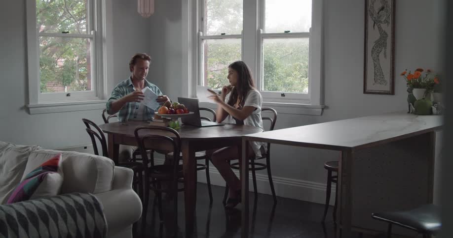 Young couple working from home on the kitchen table at day