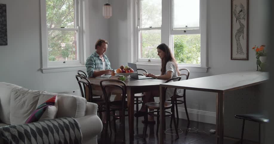 Young couple working on the dinning table in the kitchen at home