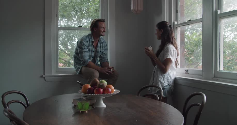 A couple talk and drink coffee in he dining room