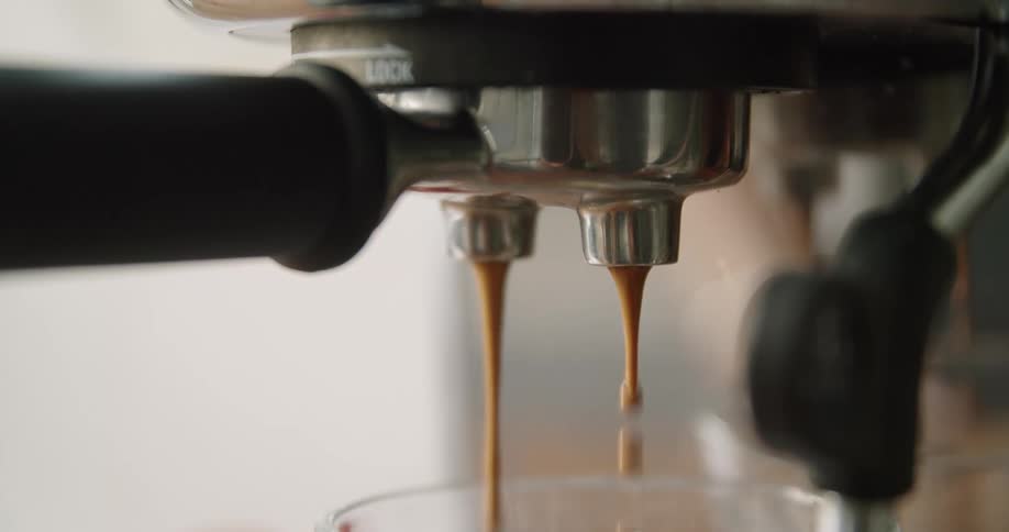 Close up of hot coffee dripping from an espresso coffee machine