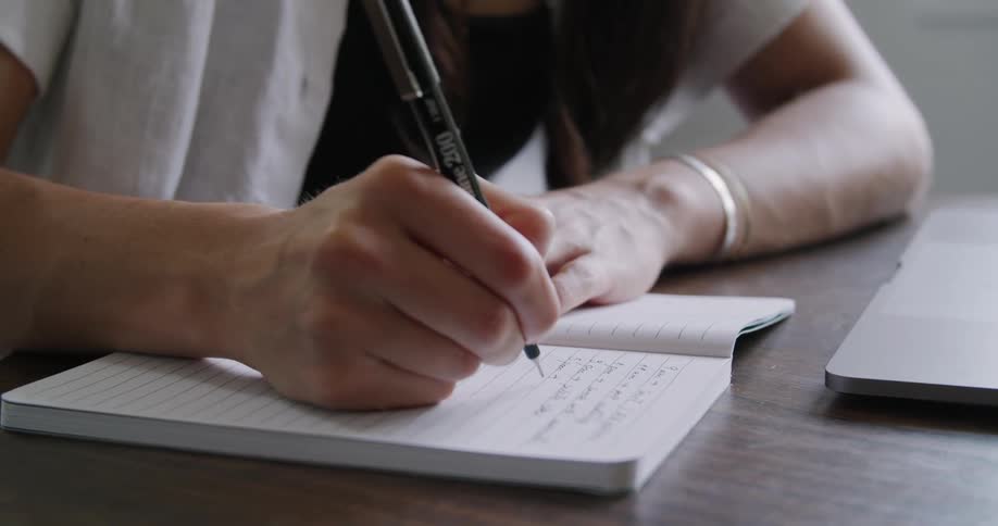 A person writing in a notebook