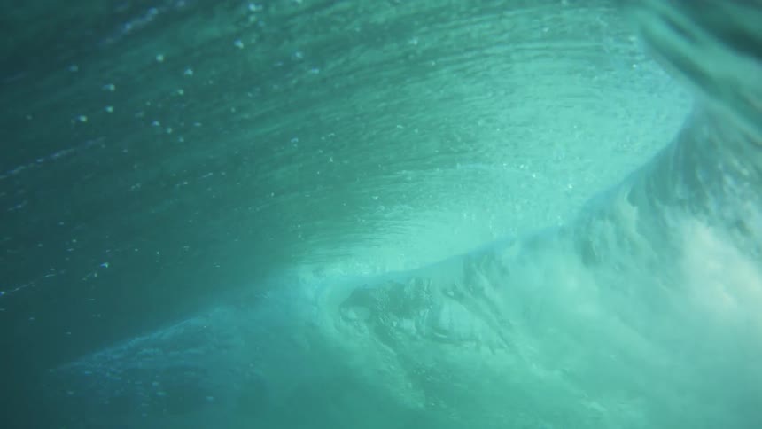 Huge wave rolls in and overhead on a clear day