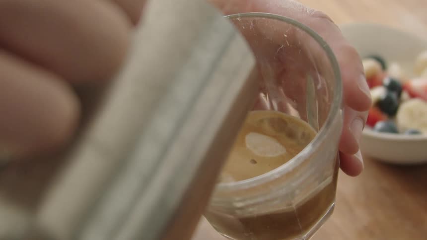 A person pouring milk into a glass of coffee