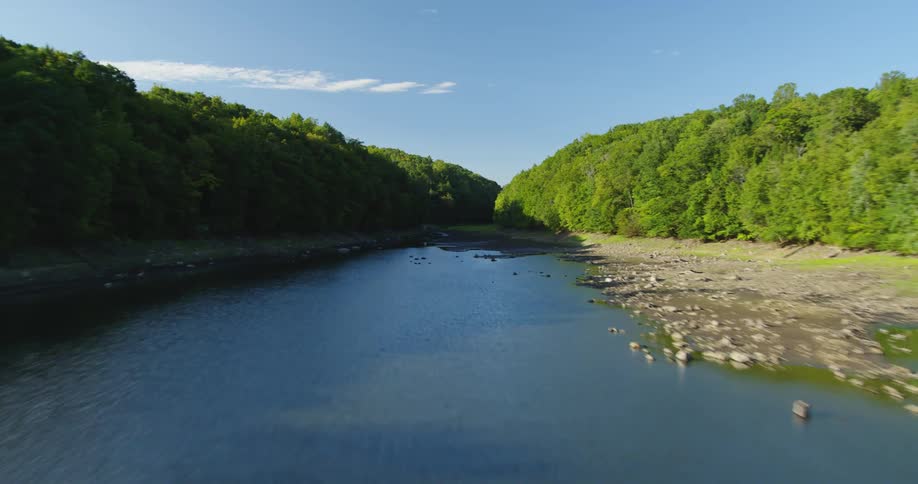 Aerial view of the calm river waters surrounded by vegetation at day time