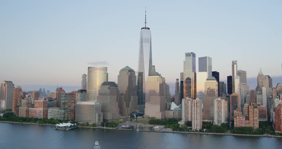 A tall skyscraper looms over the other buildings on the coast of a metropolis on a sunny day