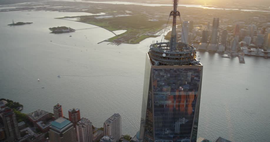 Aerial view of a high rise building with a large spire at the top in a crowded city at daytime