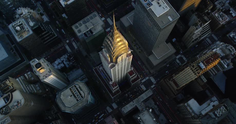 An aerial view of vehicles driving in a downtown area filled with high rise office buildings