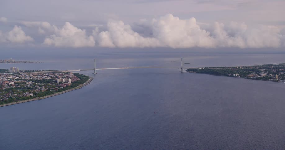 A bridge spans a strait between two sections of a metropolis during the day