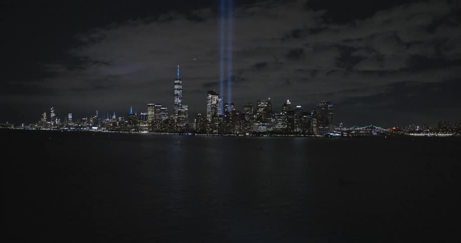 New york city skyline at night with two lights showing where the twin towers once were