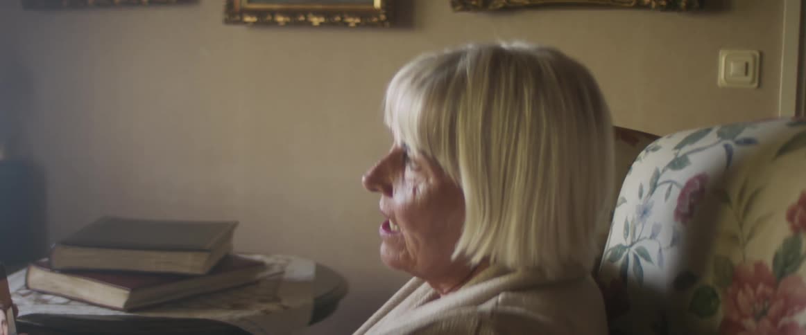 A woman sits at home and video chats on her phone