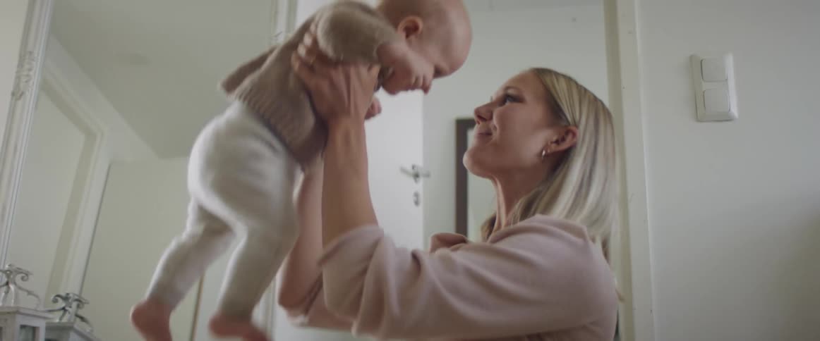 Mother playing with baby in a room at home