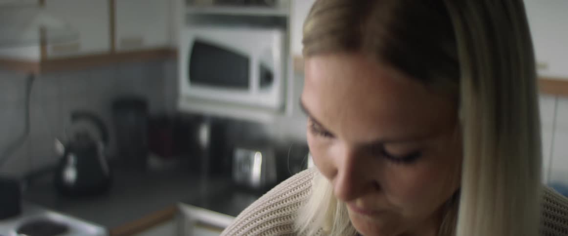 Blonde woman works in kitchen