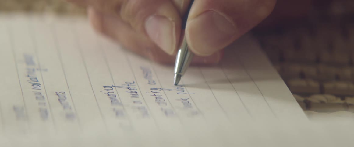 Close up of a hand writing things down in a notebook