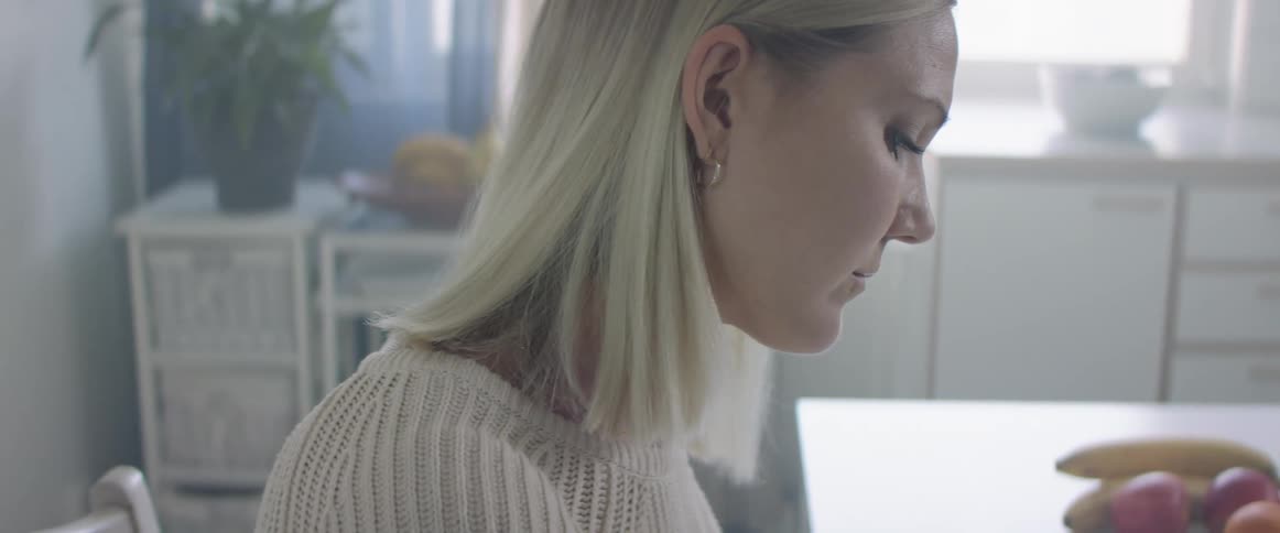 A woman is sitting in a kitchen