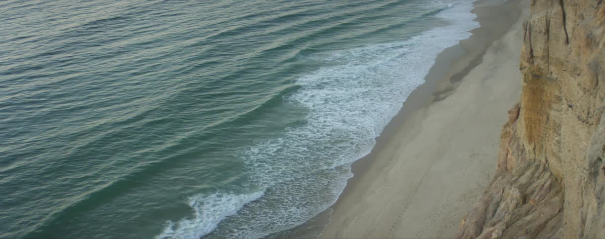 A shot of a beach by a cliff