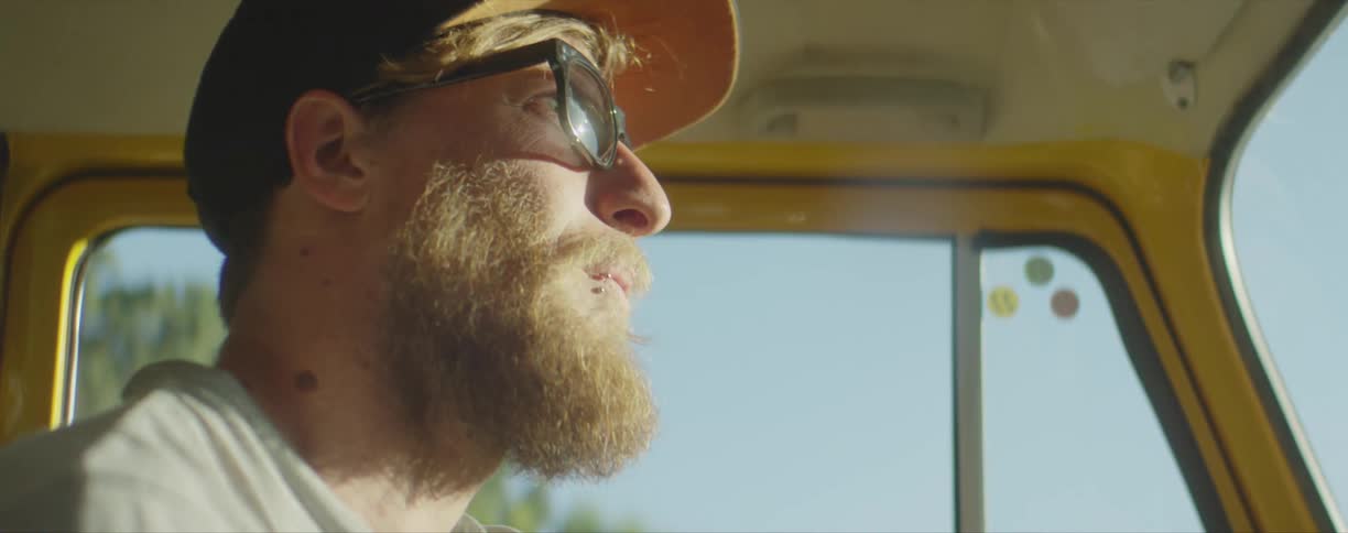 A man is driving on a sunny day