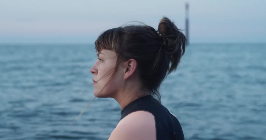A young woman looks out at the ocean