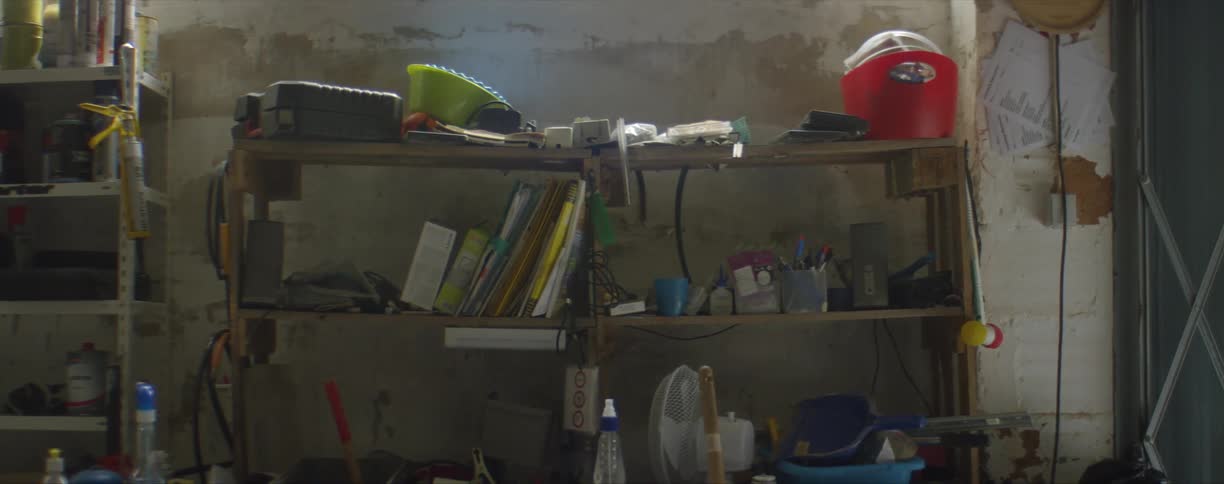 A shelf in a workshop bends with the weight of supplies on it