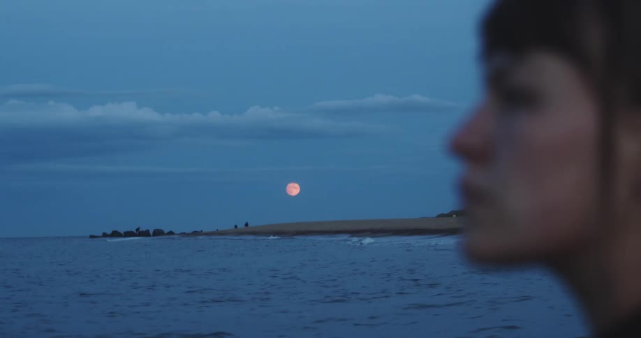 A woman standing by the moon
