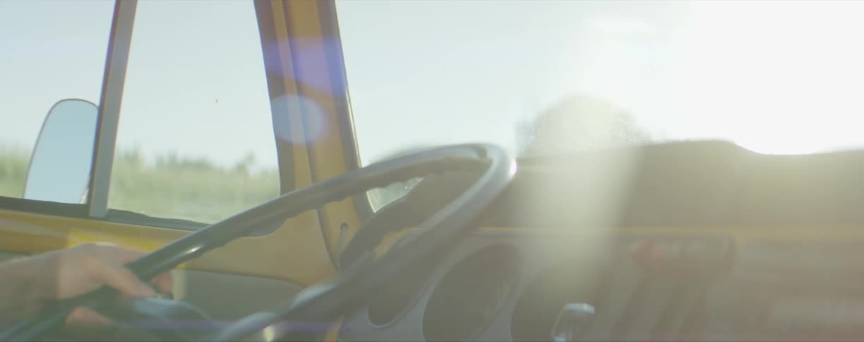 A mans hand on a steering wheel as he drives