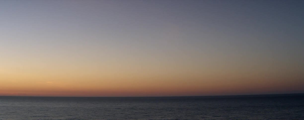 Calm ocean extending to the horizon at sunset