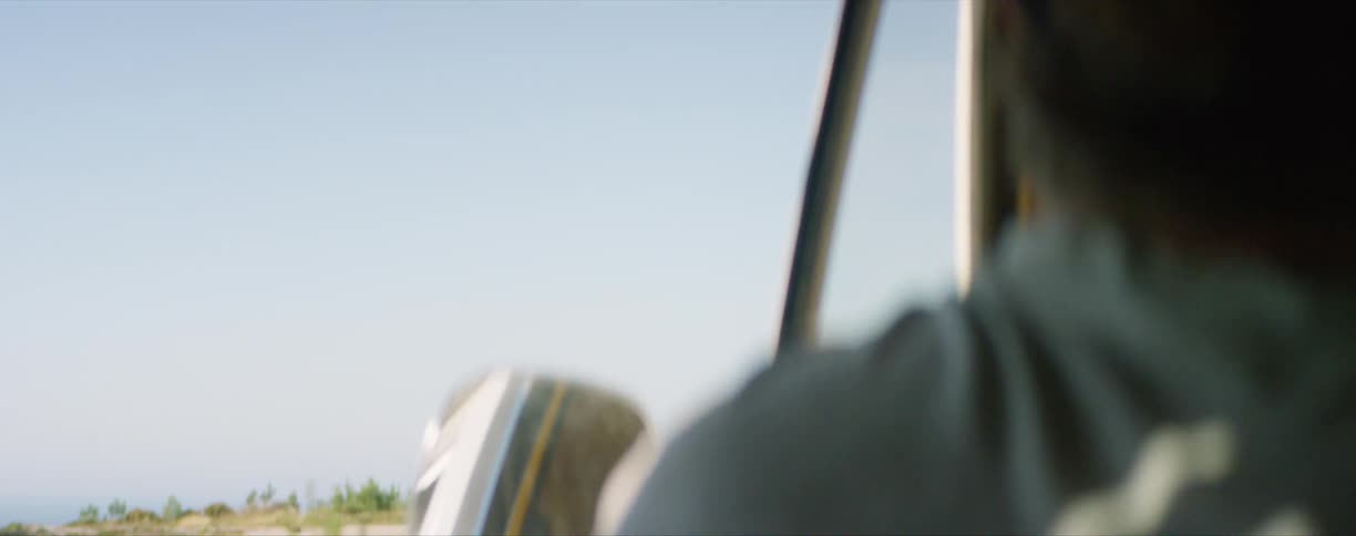 A man driving a vehicle through a rural area going to the beach