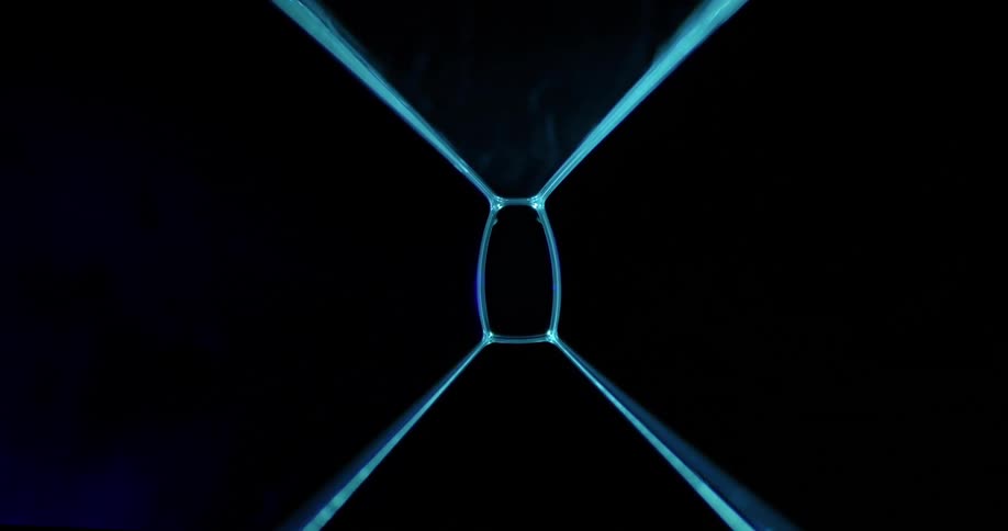 A black background with a blue light forming lines then receding to a purple shape that swirls