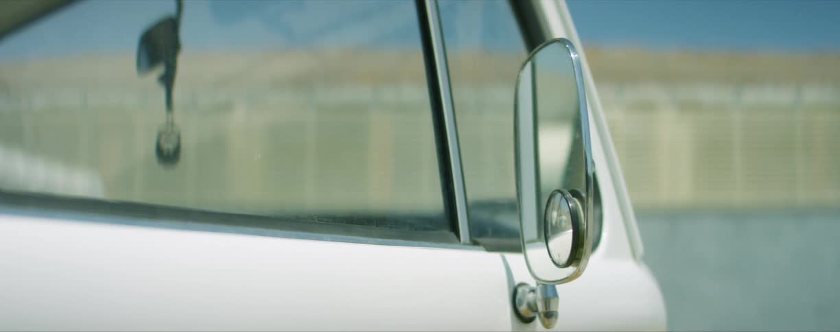 Rearview mirror on the passenger side of a van parked outdoors