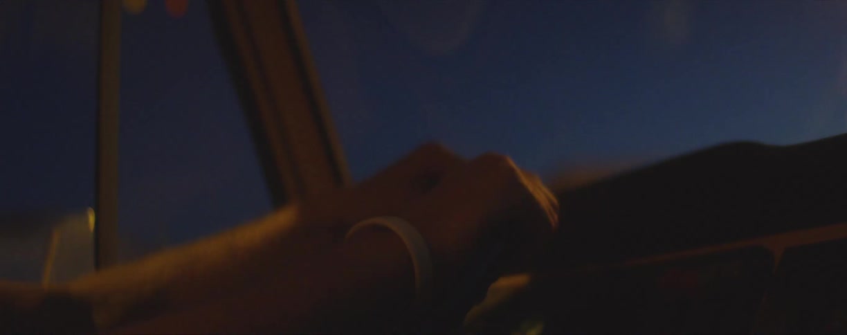 Young man driving a van through a small town at night