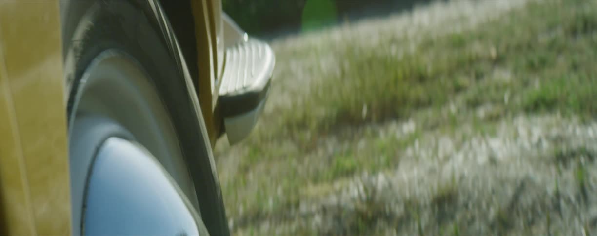 A car driving over dirt and grass on a summer day