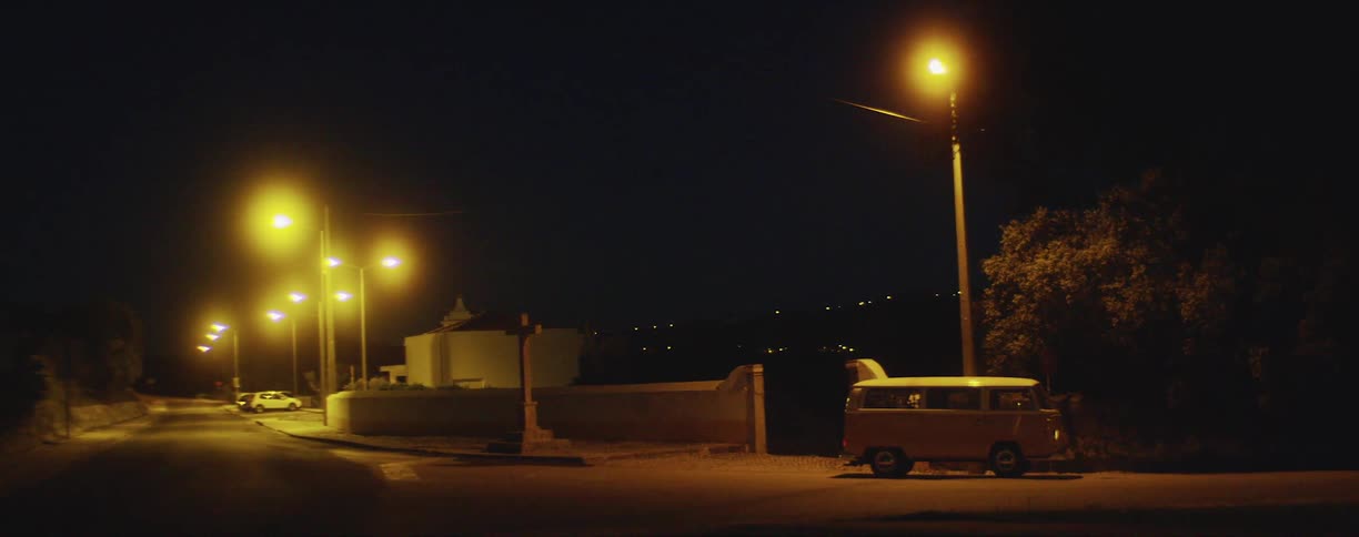A road along a cliff overlooking a city at night