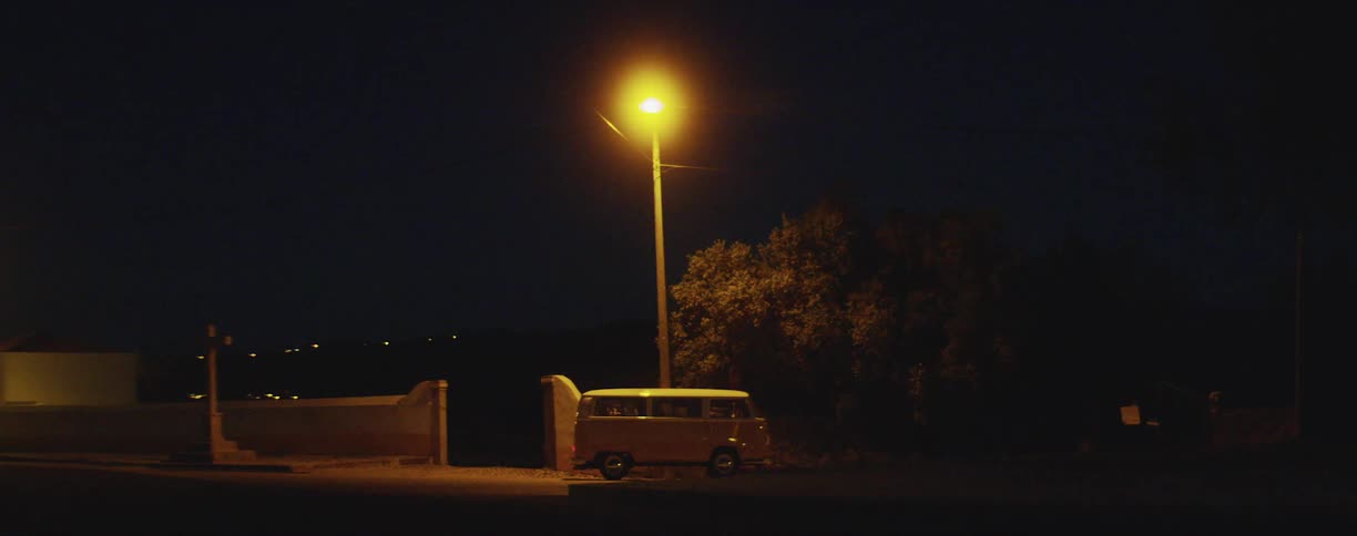 A van sitting on a street beneath a street light