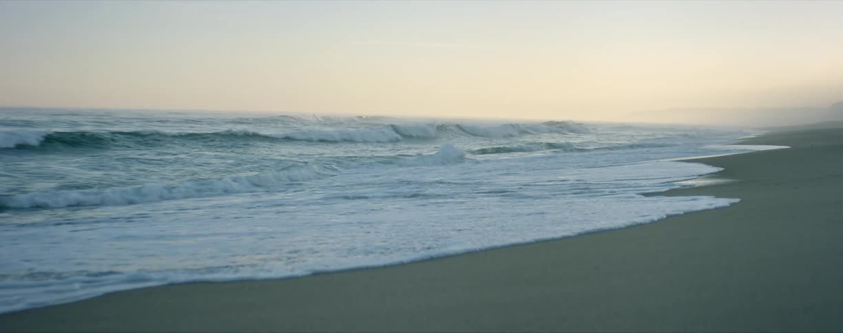 Ocean waves gently crashing on the sands beach at evening
