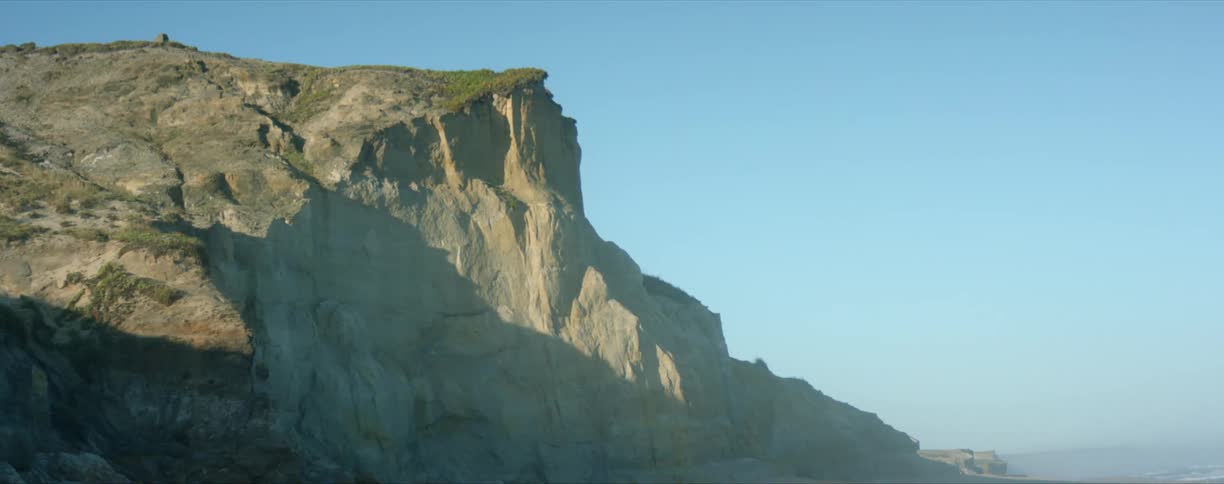 A wide shot of a cliff on a coast