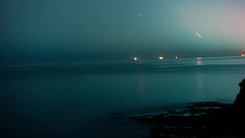 A time lapse of a coastline shows the progression from nighttime to day