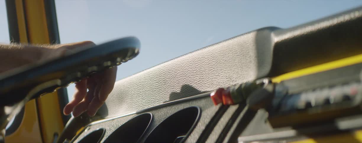 A mans hand on a steering wheel as he drives