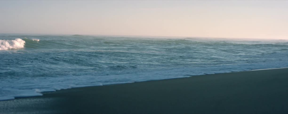 Coastline with waves rolling onto beach on a hazy day