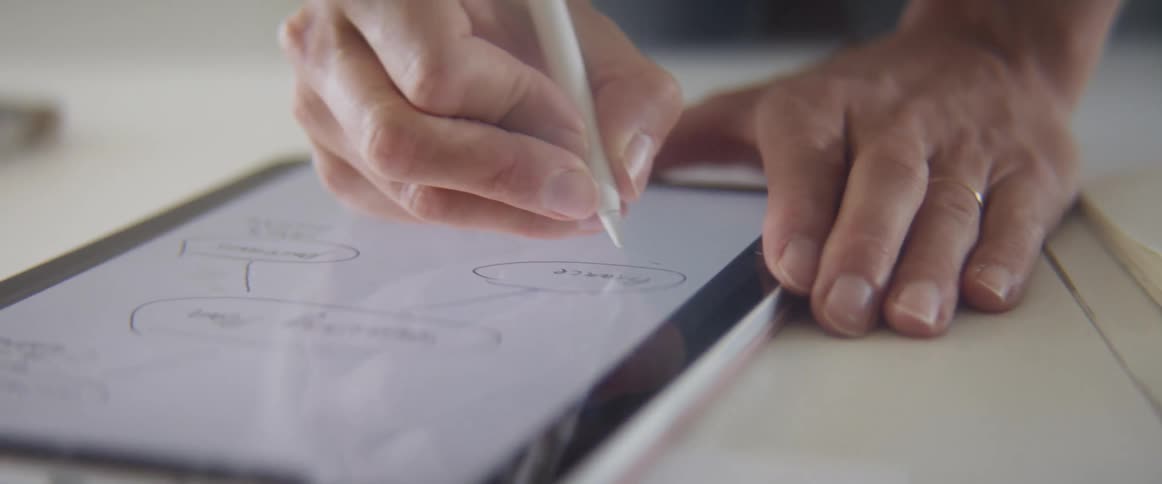 A woman writing on a tablet