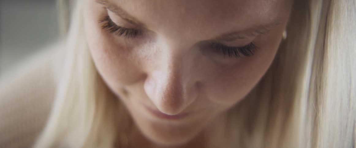 Close up of a young woman looking down and smiling