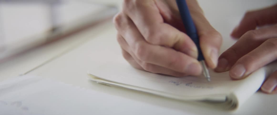 Woman writes things down in a notebook