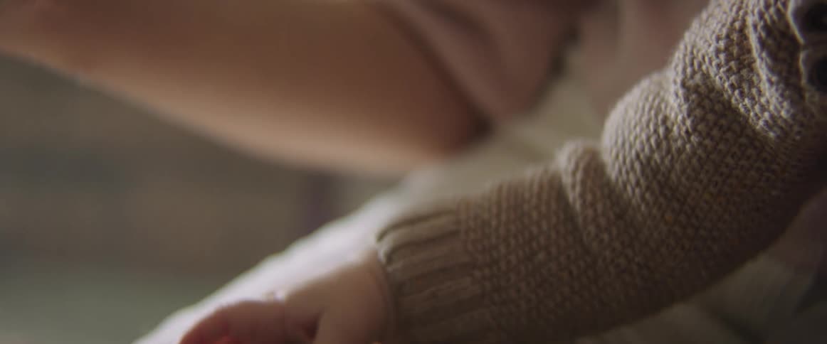 Close up of a mother with her baby son holding his tiny feet and hands
