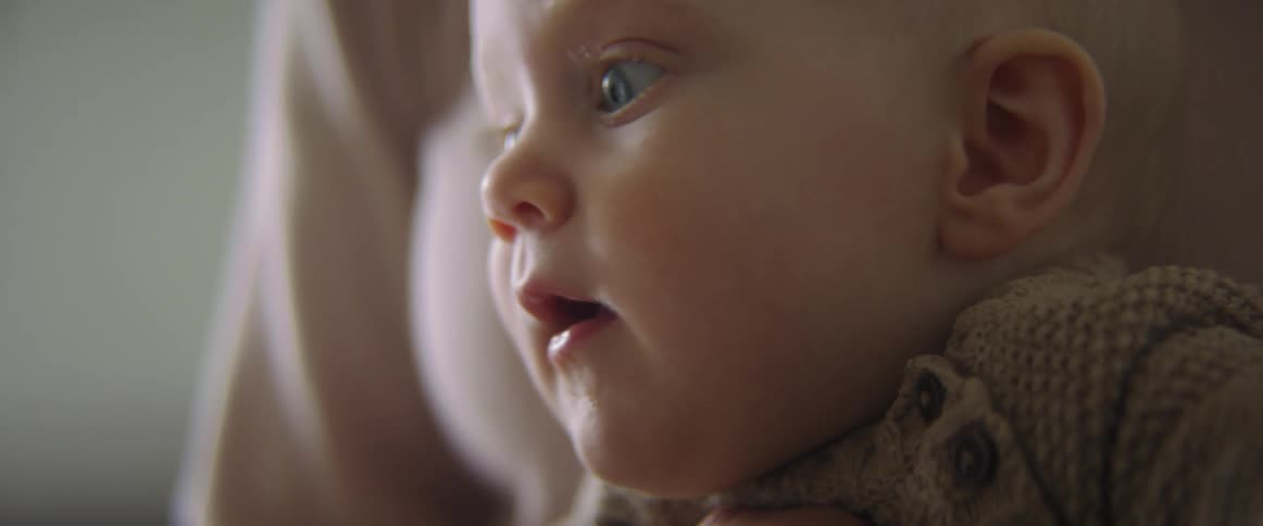 Close up of a baby watching something or someone