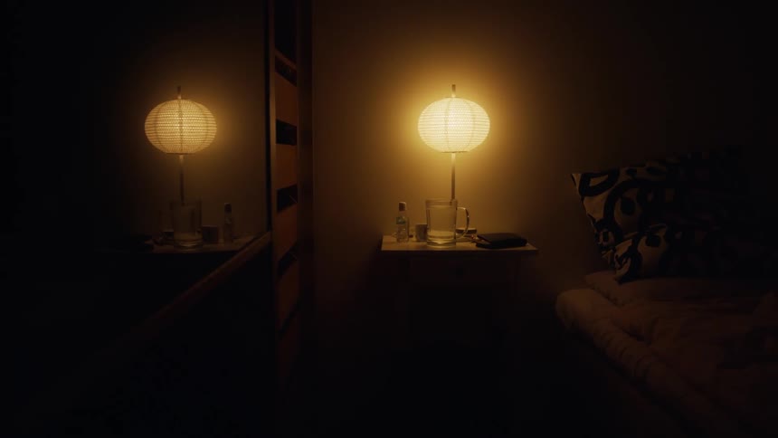 Yellow lamp on nightstand by bed