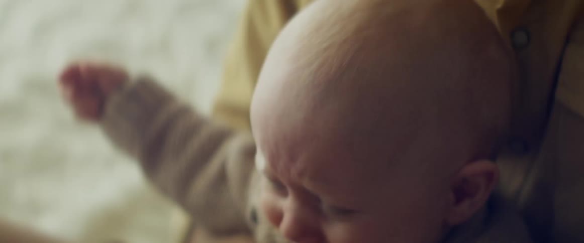A mother holds her baby as he cries